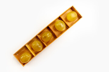 The grapes lie in a wooden cell box isolated on a white background.