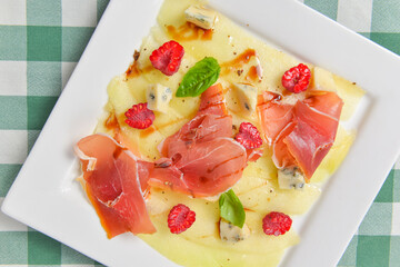 Delicious appetizer, cheese and prosciutto salad. Traditional Italian cuisine, Italian concept.