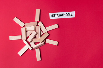 jenga wooden blocks in form of heart with copyspace and #stay at home on red background