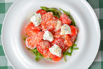 Tomato and salmon salad with cheese and spices. Traditional Italian cuisine, Italian concept.