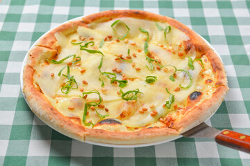 Pear and cheese pizza over green plaid table cloth. Delicious unique recipe. Traditional Italian cuisine Italian concept