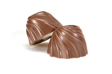 Chocolate pralines. Two dark chocolate bonbons with milk souffle fillings, macro close-up isolated on white background.