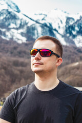 
young man on the background of mountains covered with snow