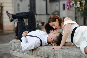 Beautiful stylish couple kissing on a date outdoors in the old city.