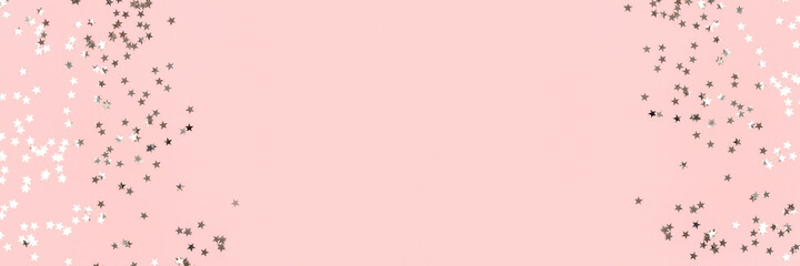 Frame made of silver stars confetti on a pink pastel background. Banner with copy space.