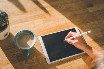 Woman using stylus pen on digital tablet top view.