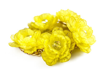 Yellow plastic flowers with a gold chain on a white background