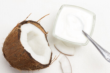 Half fresh coconut. Bowl of yogurt and spoon