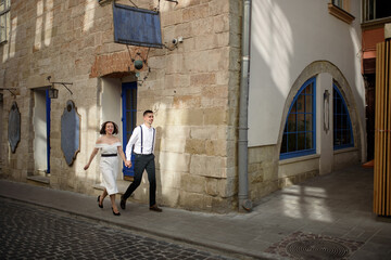 Obraz na płótnie Canvas Beautiful stylish couple walking along the street of the old city on a date.