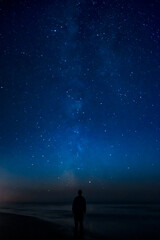 Fototapeta na wymiar Adventurous man watching the stars on a beach at night. 