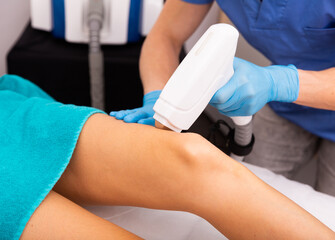 Close up view of female legs during laser hair removal cosmetology procedure in esthetic clinic