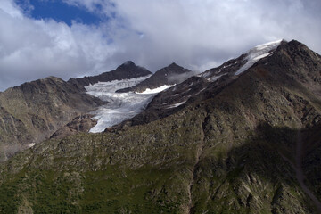 Peaks of mountains with glaciers.
View of the two peaks Bolshoy Kogutai and Maly Kogutai from the slope of Mount Cheget. Terskol, Caucasus, Russia.