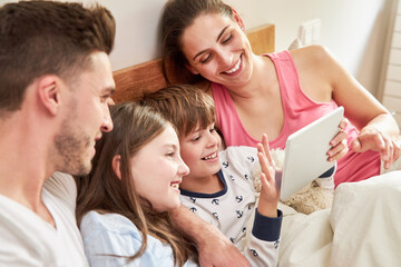 Fototapeta premium Family and kids in bed at video chat