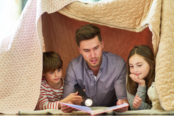 Father reads to his children from a book