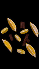 Slices and slices of lime lemon with chocolate pieces on a black background close up