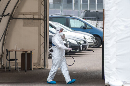 Paramedic Wearing Protective Equipment Disinfecting Mobile Testing Station Tent For Cars During Coronavirus Or COVID19 Outbreak