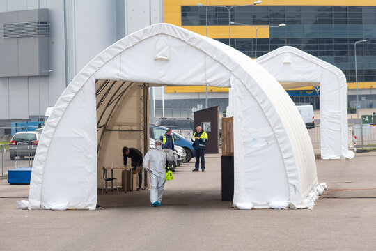 Paramedic Wearing Protective Equipment Disinfecting Mobile Testing Station Tent For Cars During Coronavirus Or COVID19 Outbreak