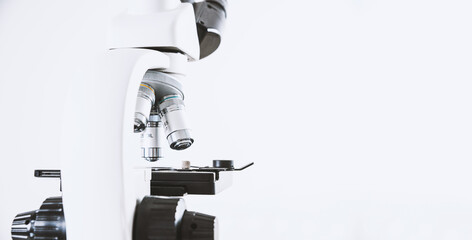 Using a biological microscope. Close-up of the microscope lens. Scientific research concept, using a microscope. Medical examinations, searching for bacteria, diseases, blood tests.