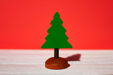 Christmas composition. Green wooden herringbone on a red background. Side view, place for text.
