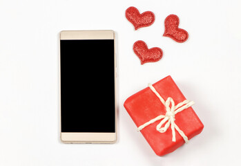 flat lay of blank screen mobile phone,red glitter hearts and red gift box on white background with copy space. valentine's day,  communication , online dating concept.