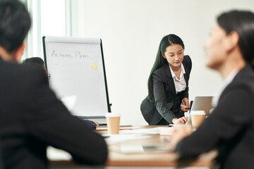 young asian businesswoman presenting actions plans to team in office