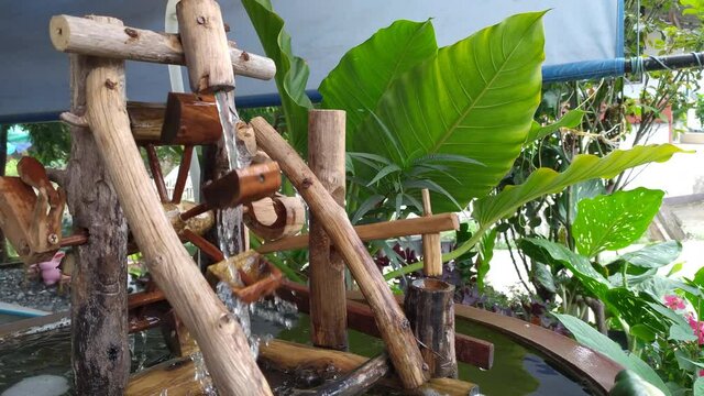 Wooden water wheels in pond. Small waterwheel spinning from the current garden. Rotates under sun water falls. cute artifact