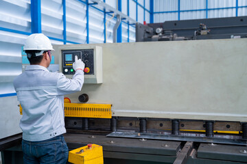 Asian worker wearing a safety suit and setting Hydraulic Press Break Machine and Prepared Sheet...