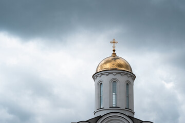  White church with golden dome and cross close up