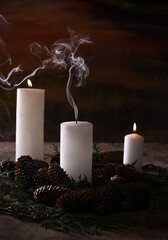 Christmas candles with lights and fir cones