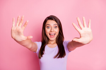 Portrait of amazed young lady show ten fingers wear casual violet cloth isolated on pink color background
