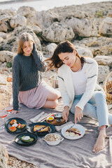 Two women female friends having picnic brunch with fresh homemade food and champagne.