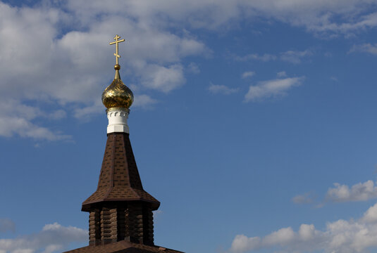 Wooden church with golden dome and cross close up