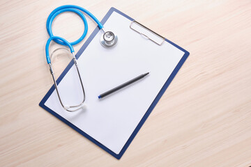pills, stethoscope and note pad on the wooden table