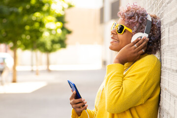 girl with mobile phone and headphones on the city street