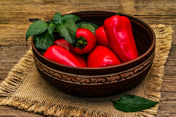 Ripe whole red mini peppers in clay bowl