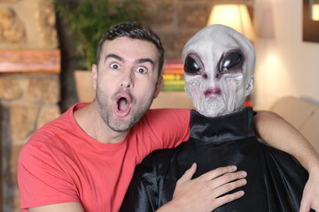 Man taking a picture with funny looking alien  