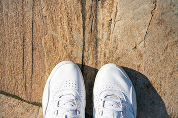 white sneakers on stone floor top view