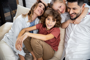 Family with kids laughing while sitting on couch