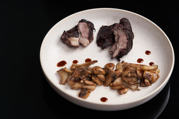 Baked lamb chops and mushrooms on a white plate.