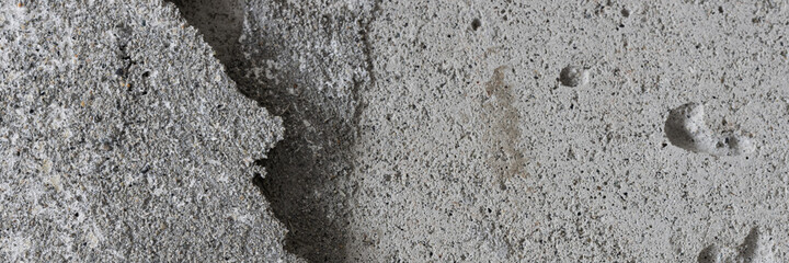 Texture of an old cracked concrete wall. Grungy gray concrete surface with shadow. Wide panoramic background for design.
