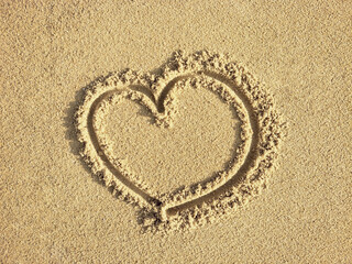 heart shape draw on wet beach sand