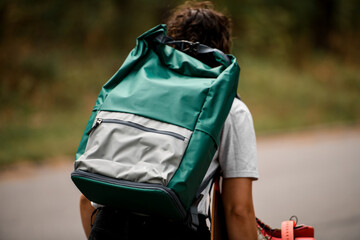 close-up of bright green backpack on the shoulders of young curly girl