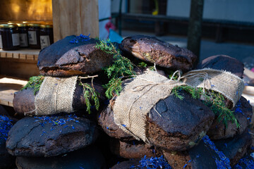 Fototapeta na wymiar Homemade black cereal and juniper bread with hemp seeds in a street food traditional market