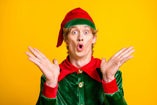 Photo of young man raise arms amazed face wear elf velvet green costume headwear isolated yellow color background