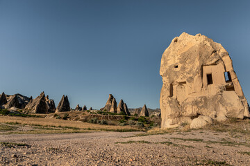 Cappadocia scenery with ruins and volcanic formations.