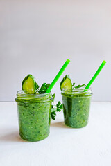 Green cocktail of spinach, lemon, cucumber and parsley on a light background. The concept of healthy nutrition, detox, green, diet, vegan, keto, fit. Copy space. vertical.