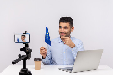 Positive politician, ambassador or lawyer holding European Union flag and pointing finger while...