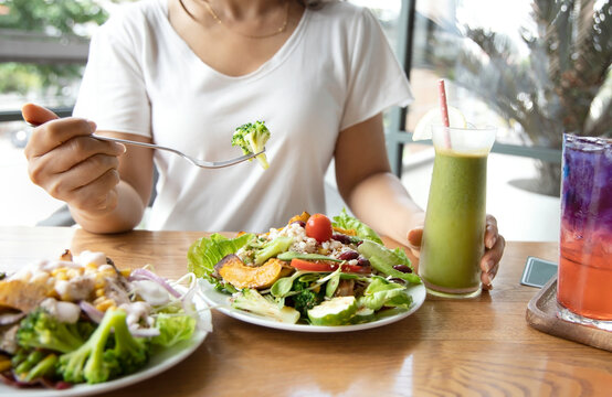 Selective focus of woman with Broccoli and salad which she make a Intermittent fasting with a Healthy food of salad and detox drink ,Healthy lifestyle Concept.