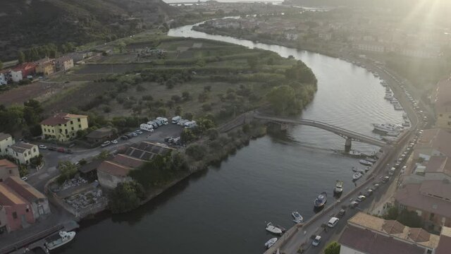 Time lapse zoom out aerial shot for Temo river of Sardinia with parked boats and water bridge connecting two sides of the city