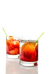 Fototapeta na wymiar Negroni cocktail with ice cubes and orange slices in glass with straw isolated on white.Space for text